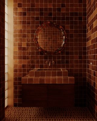 tiled bathroom with round resin mirror