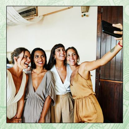 A newlywed couple takes a selfie with two of their guests.
