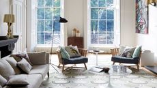 georgian house living room with modern furniture, geometric print rug, and two large windows