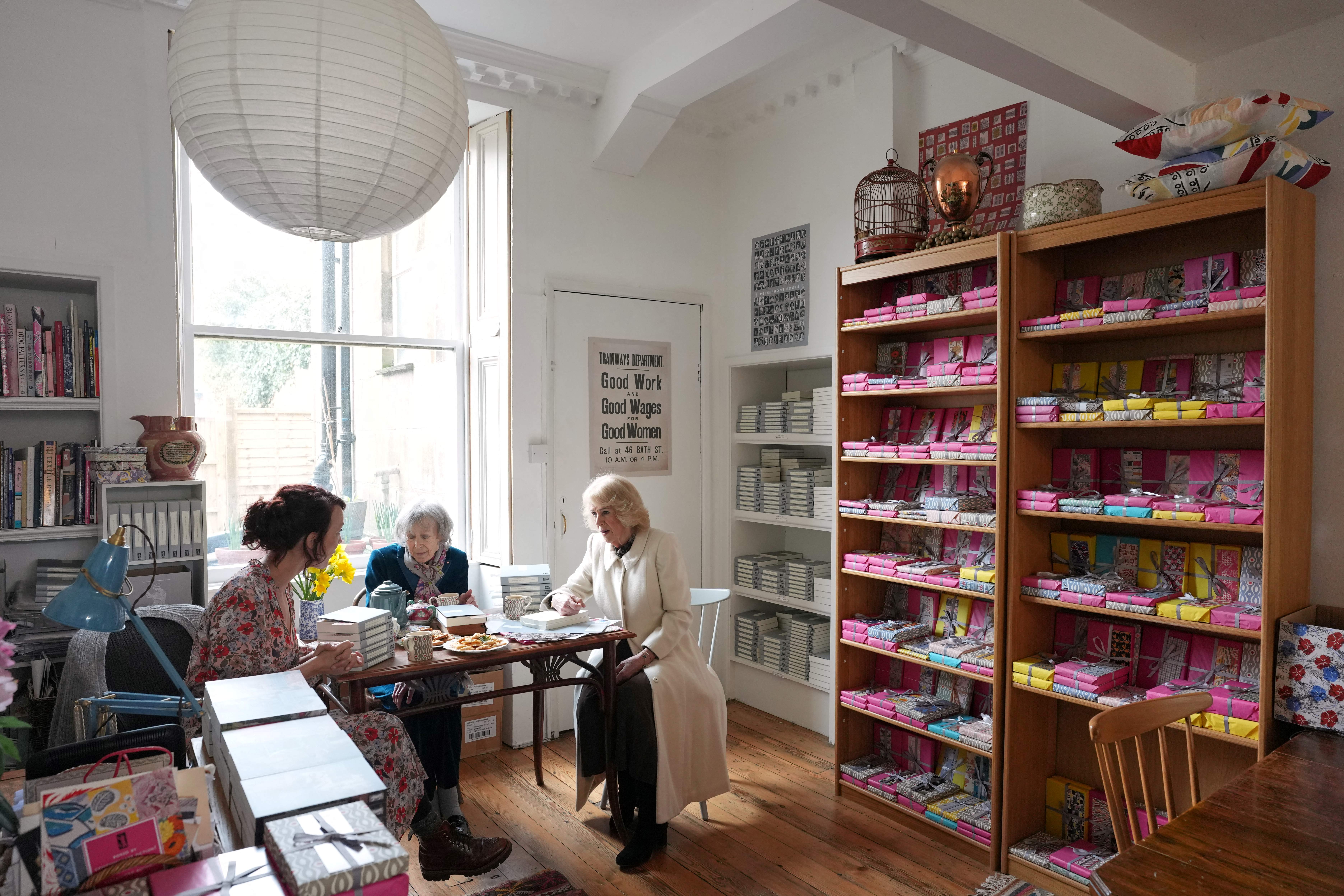 Britain's Queen Camilla (R) talks to shop founder Nicola Beauman (C) and her daughter and managing director Francesca Beauman (L) as she visits Persephone Books, an independent publisher and bookshop, in the city of Bath, south-west England on February 17, 2026