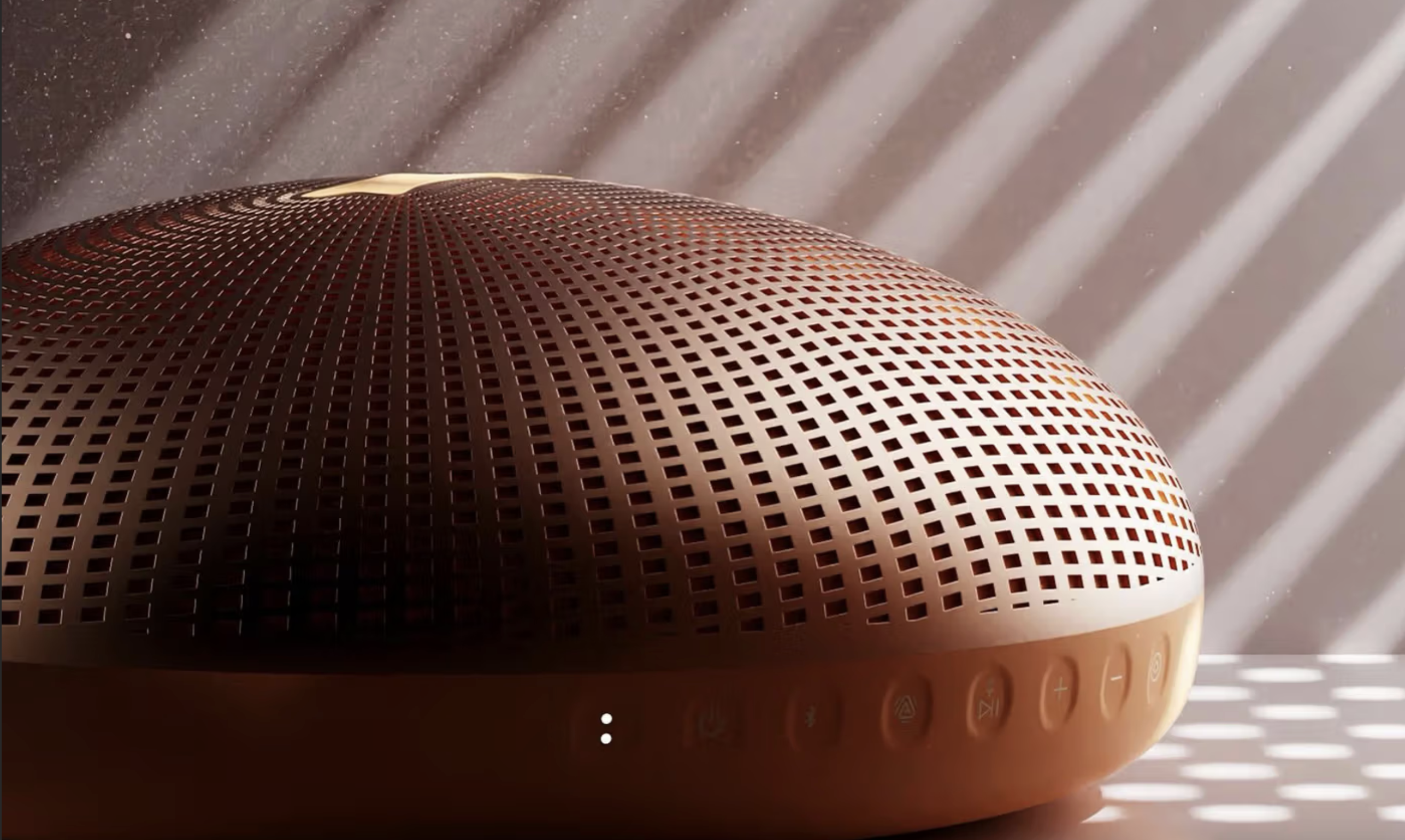 A Justin Bieber speaker in orange, showing some buttons on the side, in mood lighting