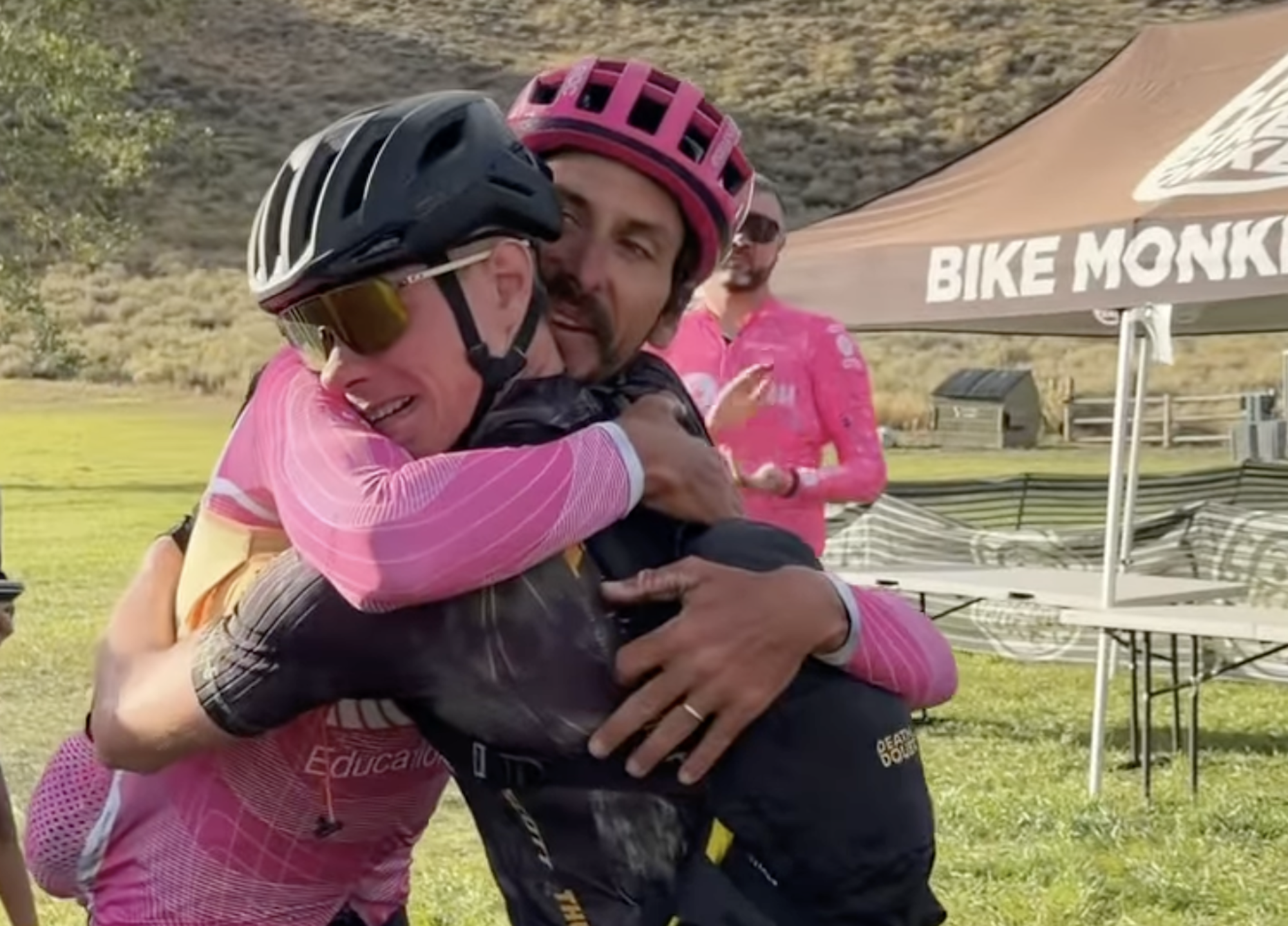 Lachlan Morton hugs his Rebecca's Private Idaho teammate Christian Loafman after the pair completed the 118-mile long queen stage on September 13 as part of Adventure For all