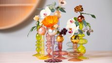 A set of mini vases with cut flowers like orchids and roses