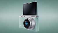 Samsung NX Mini against an aqua-colored background