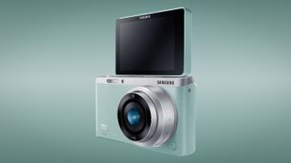 Samsung NX Mini against an aqua-colored background