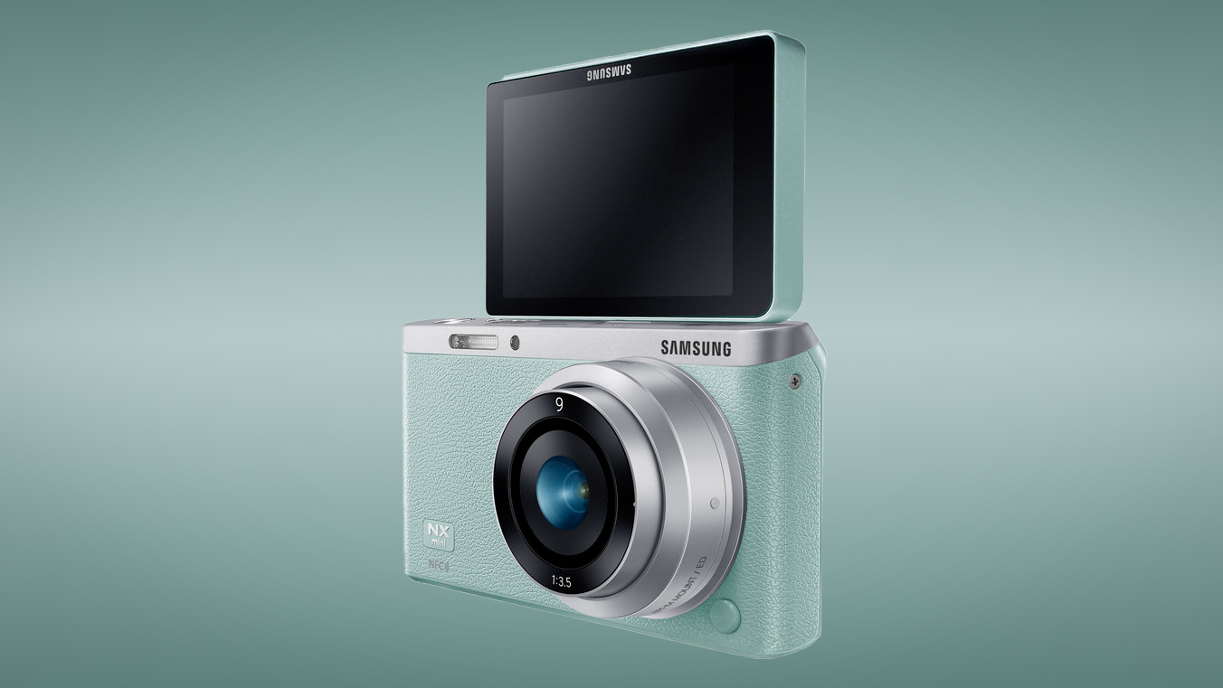 Samsung NX Mini against an aqua-colored background