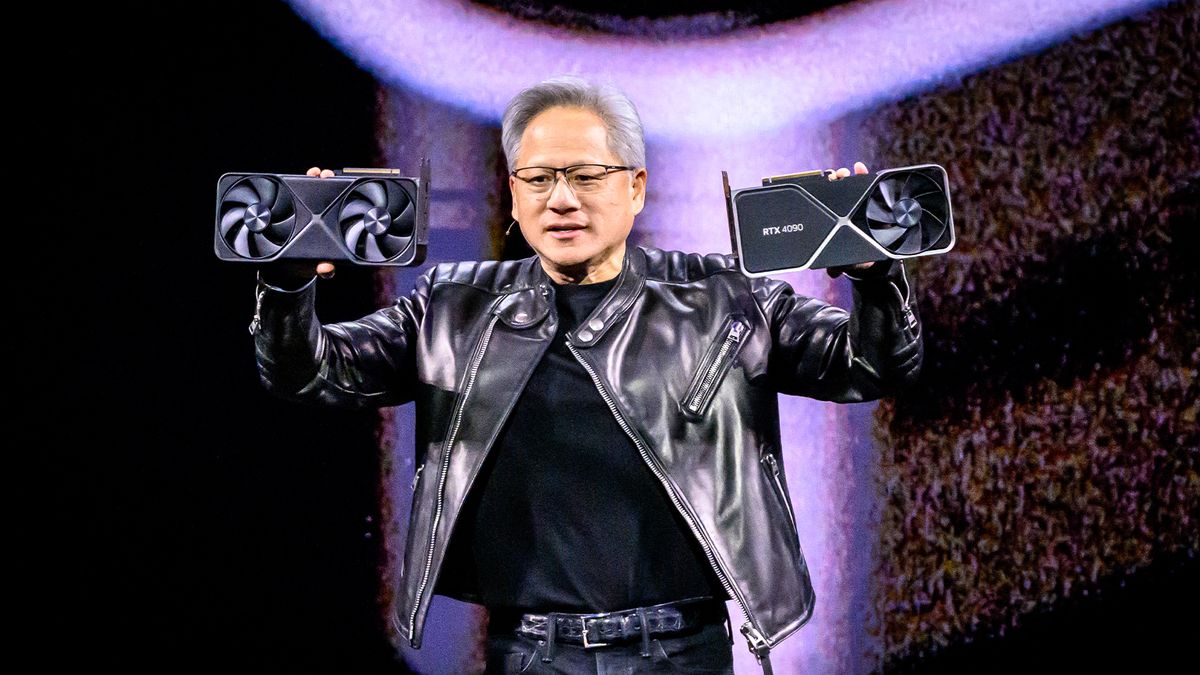 Jensen Huang, co-founder and chief executive of Nvidia pictured on stage at Nvidia GTC 2025 holding two GPUs. 