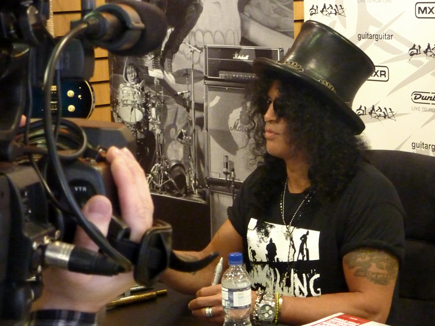 Slash signing memorabilia for fans at GuitarGuitar in Epsom