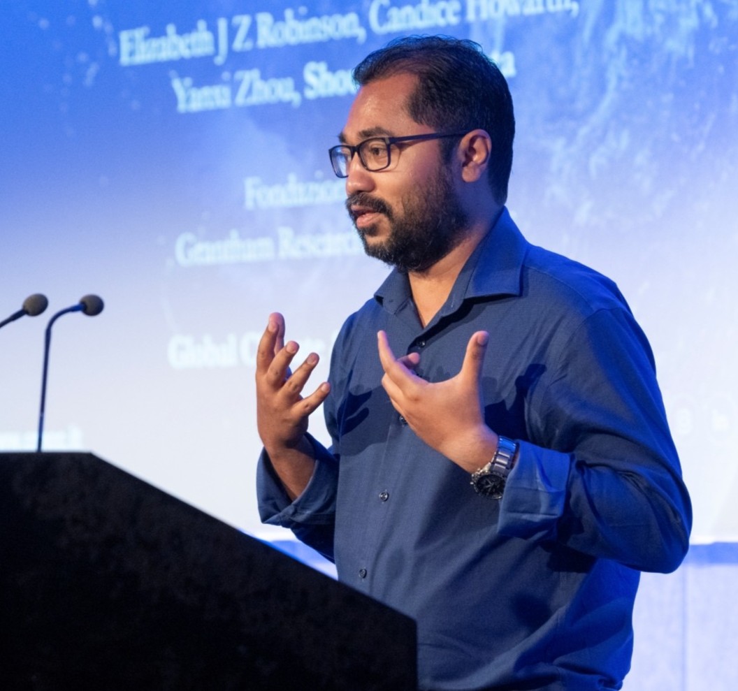 A photo of Shouro Dasgupta presenting his research at a conference.