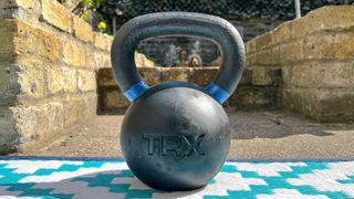 TRX Kettlebell outside in the sunshine, with a dog visible through the handle