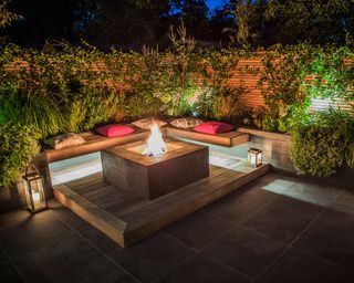 A decked built in seating area with fire pit table