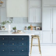Kitchen with grey wall cabinets, navy island and kitchen stools