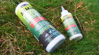A bottle of Silca tubeless sealant and replensher lying on grass