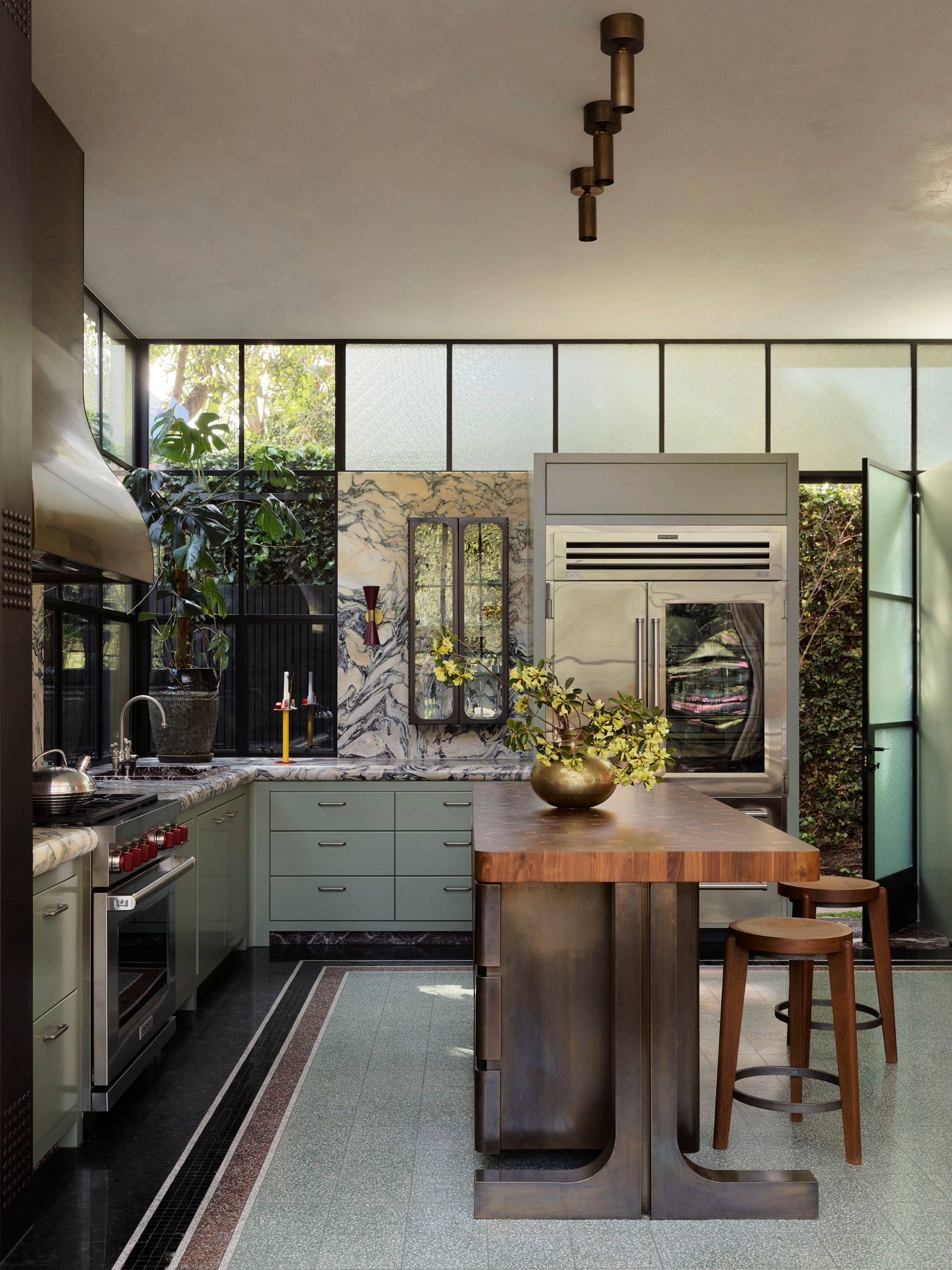 a sage green and stone kitchen with a timber island bench
