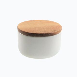 A white stoneware canister with a wooden lid