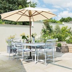 Metal outdoor dining set with parasol in terraced patio srea