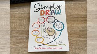 a picture of Simply Draw, one of the best drawing books, on a desk