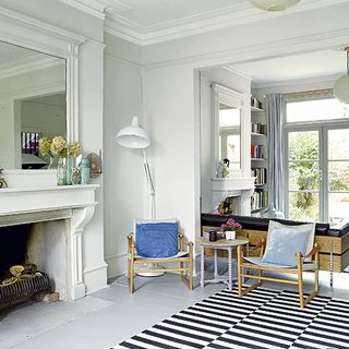 sitting room with fireplace and white wall and armchair