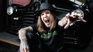 Children Of Bodom’s Alexi Laiho sitting in front of a vintage car