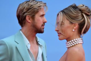 Ryan Gosling and Margot Robbie look at one another on the red carpet