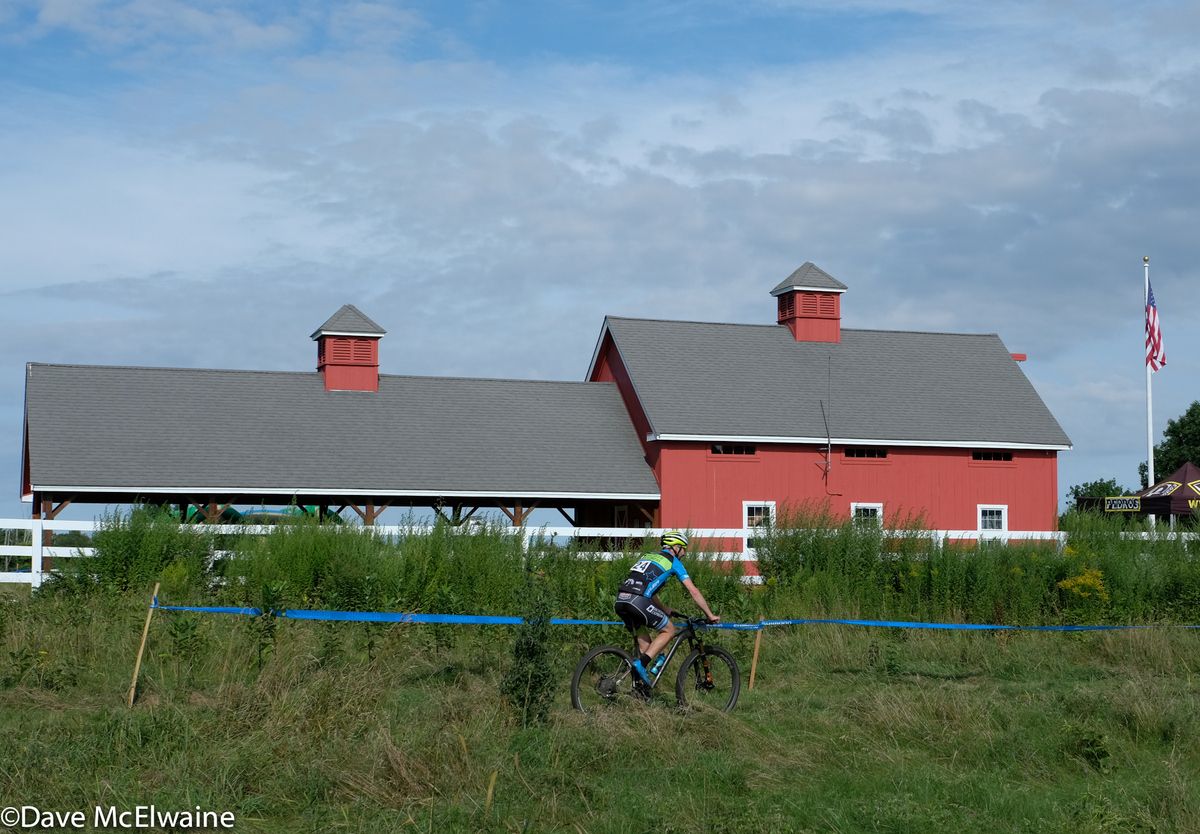 A rider passes by the barn on the Adam&rsquo;s Farm