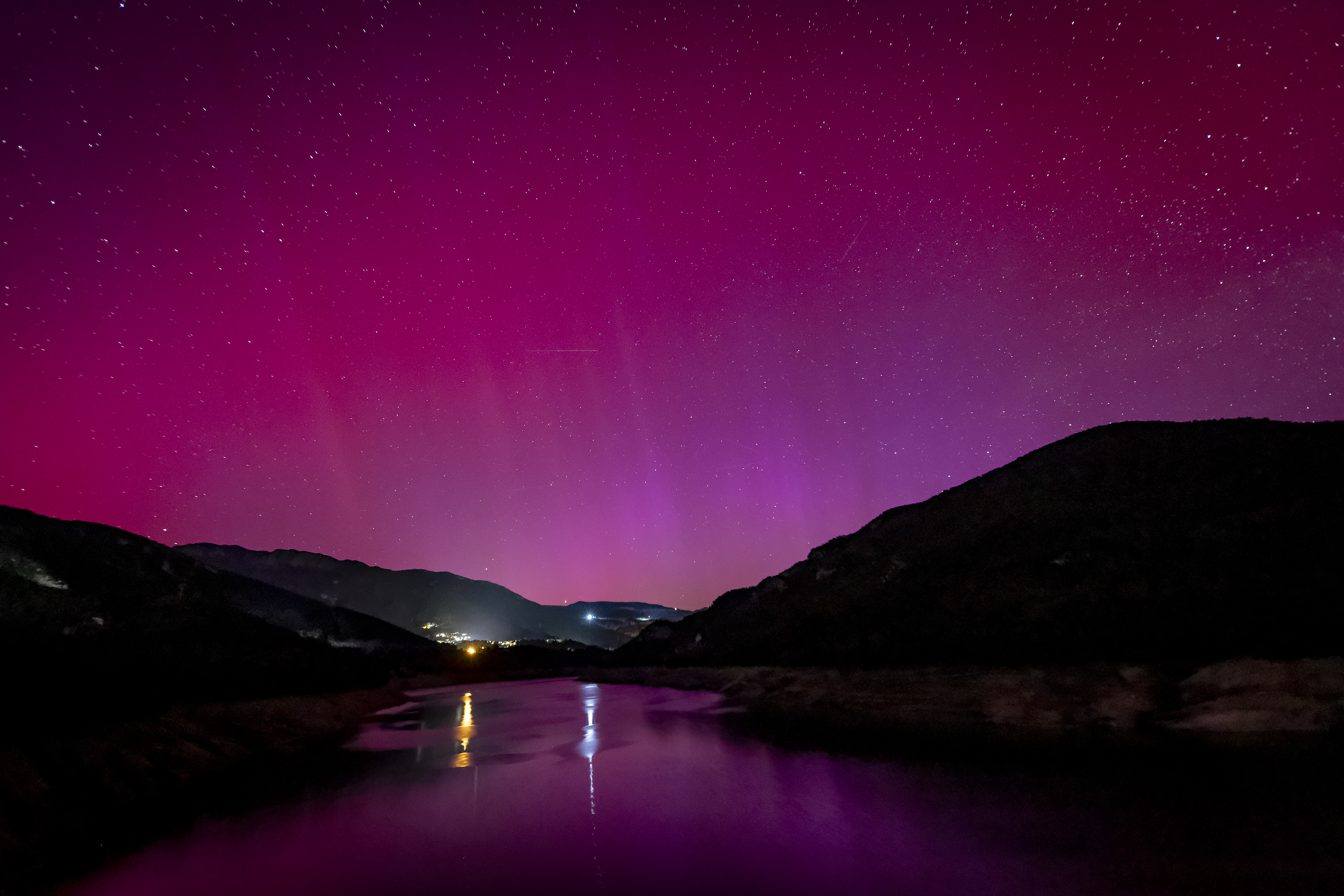 Pink and purple hues of the northern lights over Berga, Spain.
