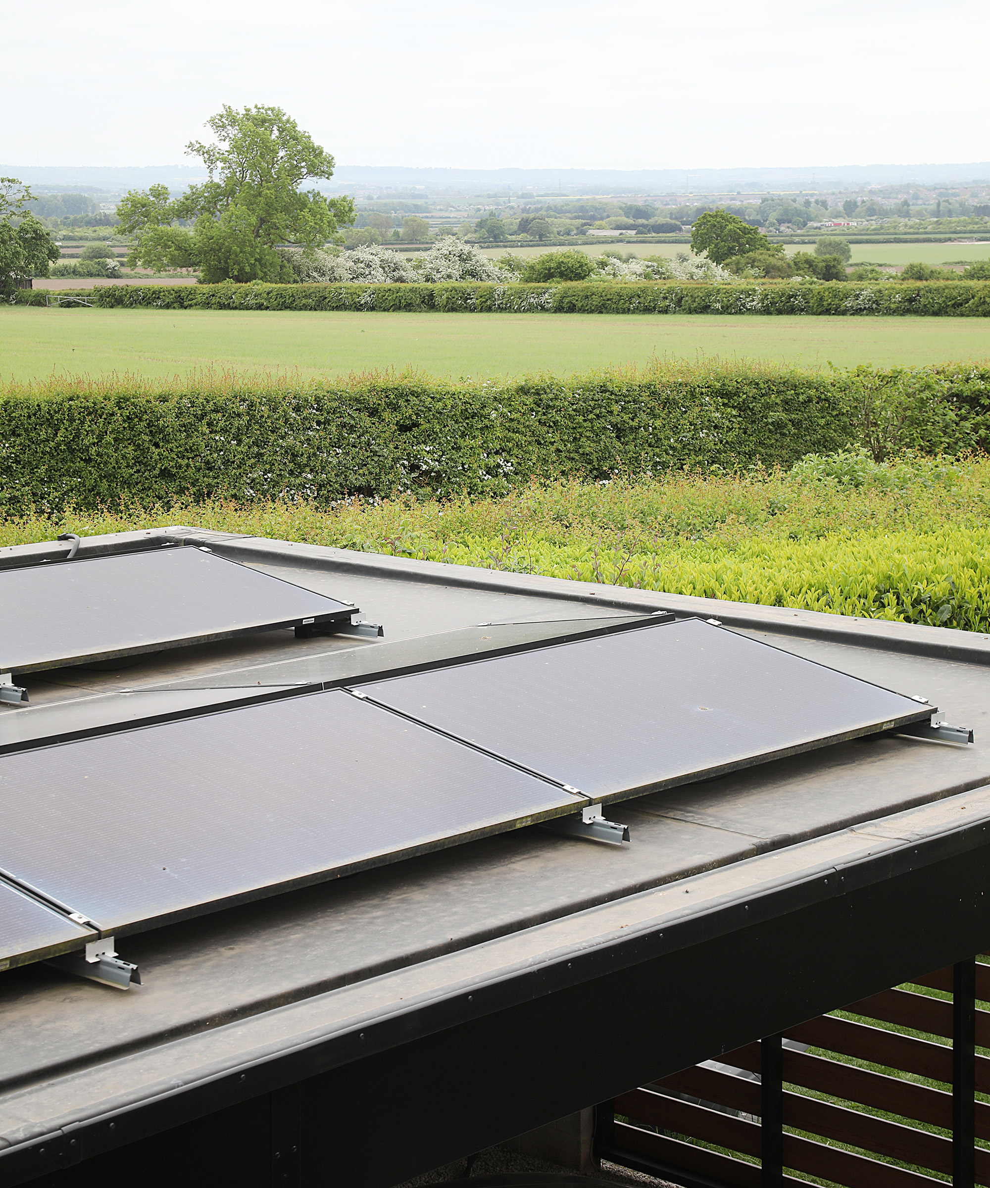 View over a roof with solar panels to the countryside beyond
