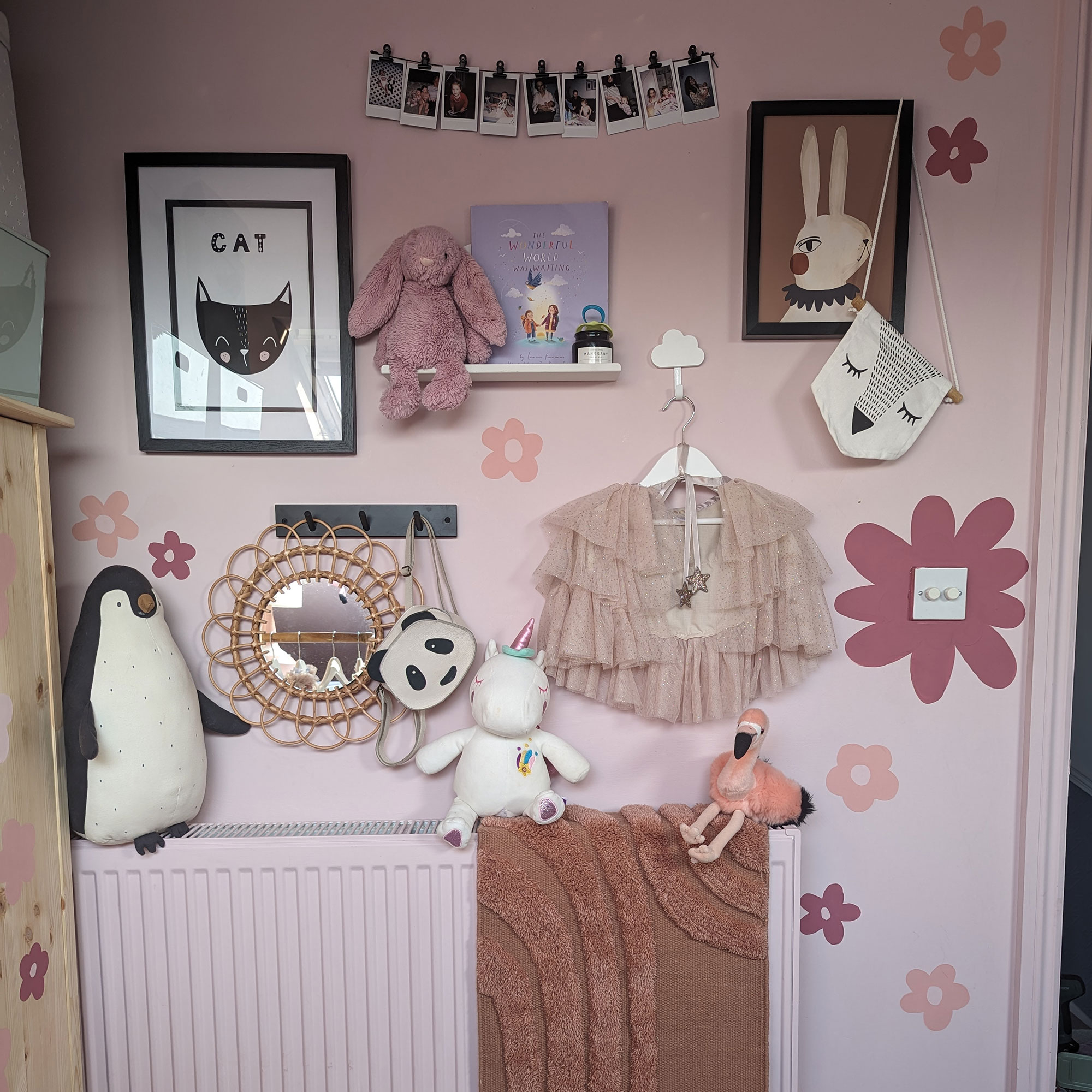 Pink girl's bedroom with flower decals, cuddly toys and illustrations