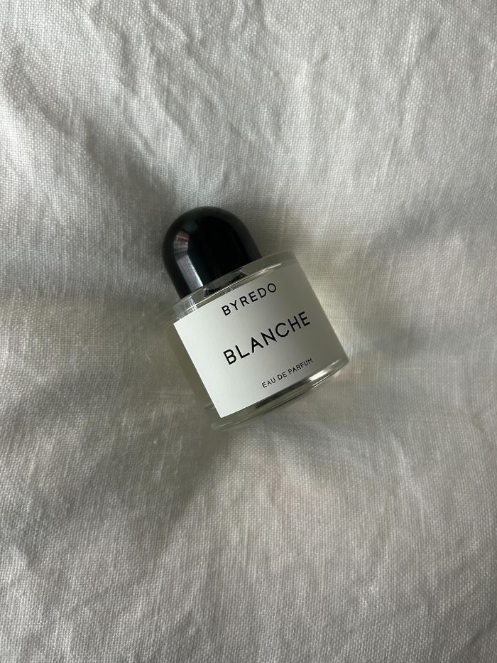 Byredo Blanche perfume on a white linen background