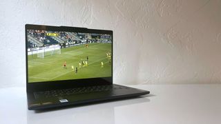 The Lenovo IdeaPad 5 2-in-1 laptop with lid open showing a soccer match