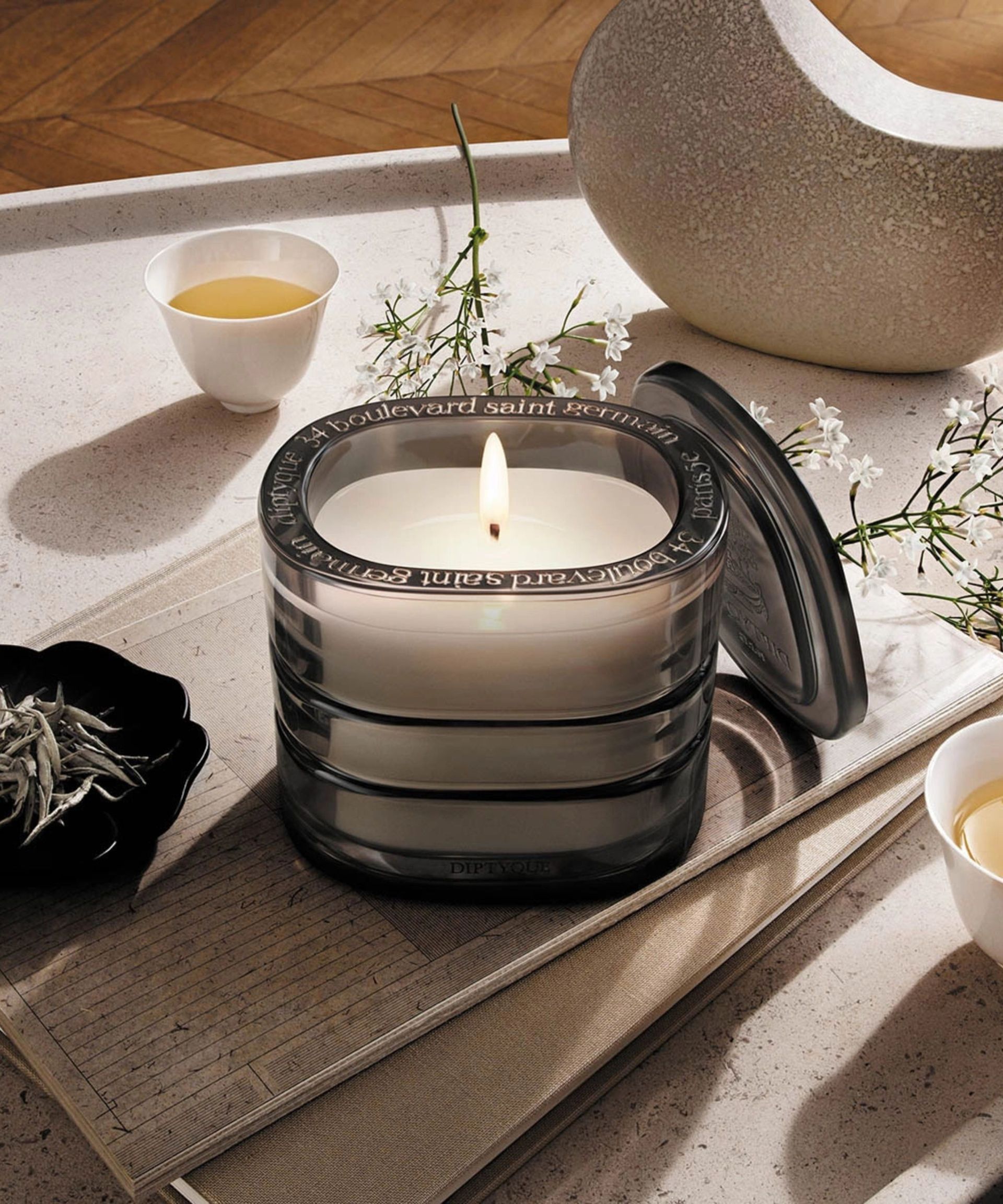 Diptyque candle on a white tray.