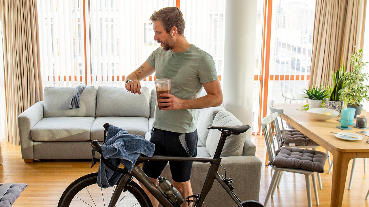 Man holding a protein shake after an indoor cycle 