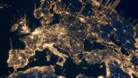 Satellite image of European continent with beams of light emanating from metro areas