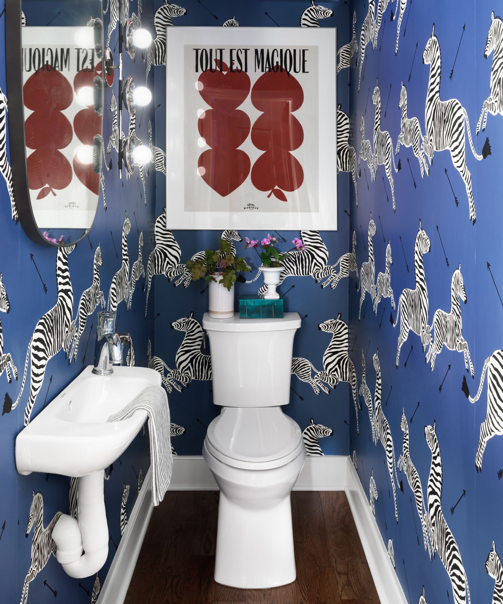 Powder room with blue zebra wallpaper and print above the toilet