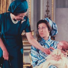 Queen Elizabeth smiling at baby Peter Phillips being held by Princess Anne
