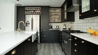 black kitchen with white marble worktops white metro tiled walls
