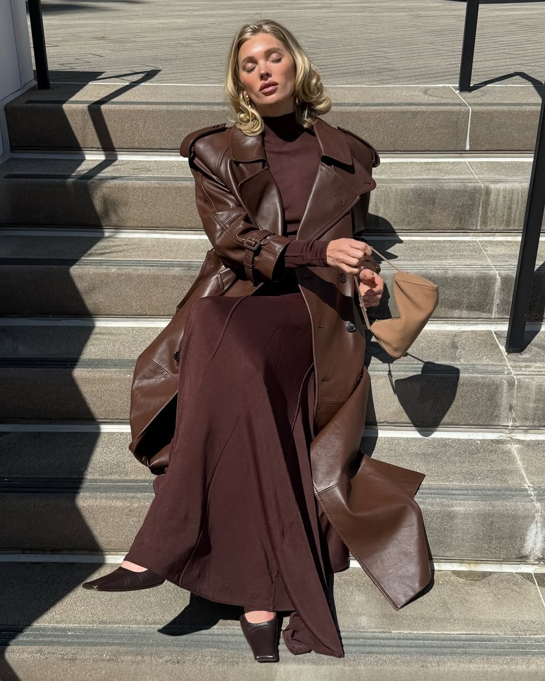 Woman wearing an elegant outfit idea that includes a floor-sweeping trench coat.