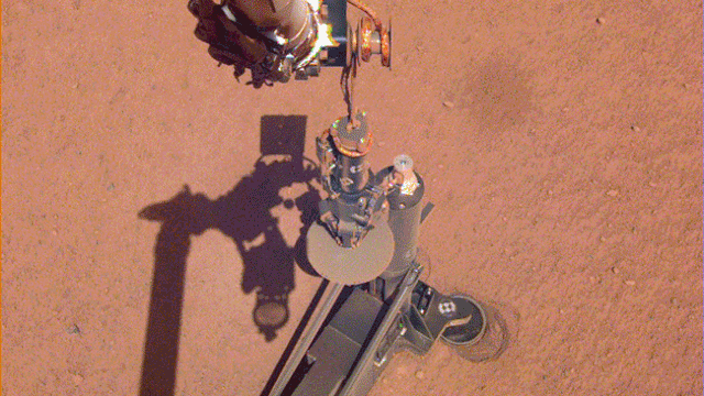The Instrument Deployment Camera on NASA's InSight lander caught sight of its robotic arm moving the support structure for the "mole," a digging instrument that has stopped tunneling down through the Martian surface.