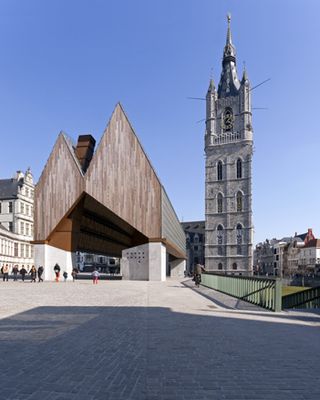 The towering hall is a timber structure that filters the light through slits in its roof