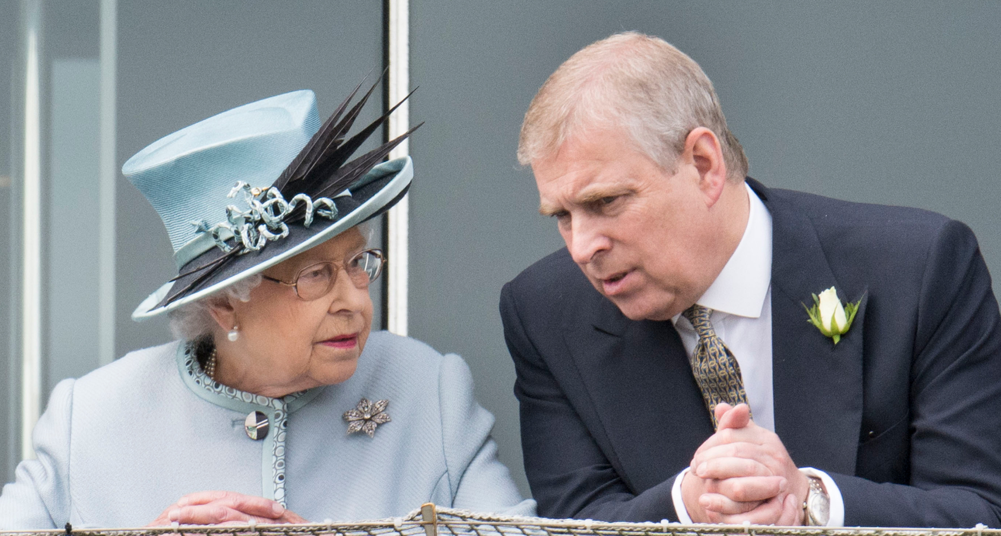 Queen Elizabeth wearing a light blue hat and coat talking to ex-Prince Andrew leaning over a railing
