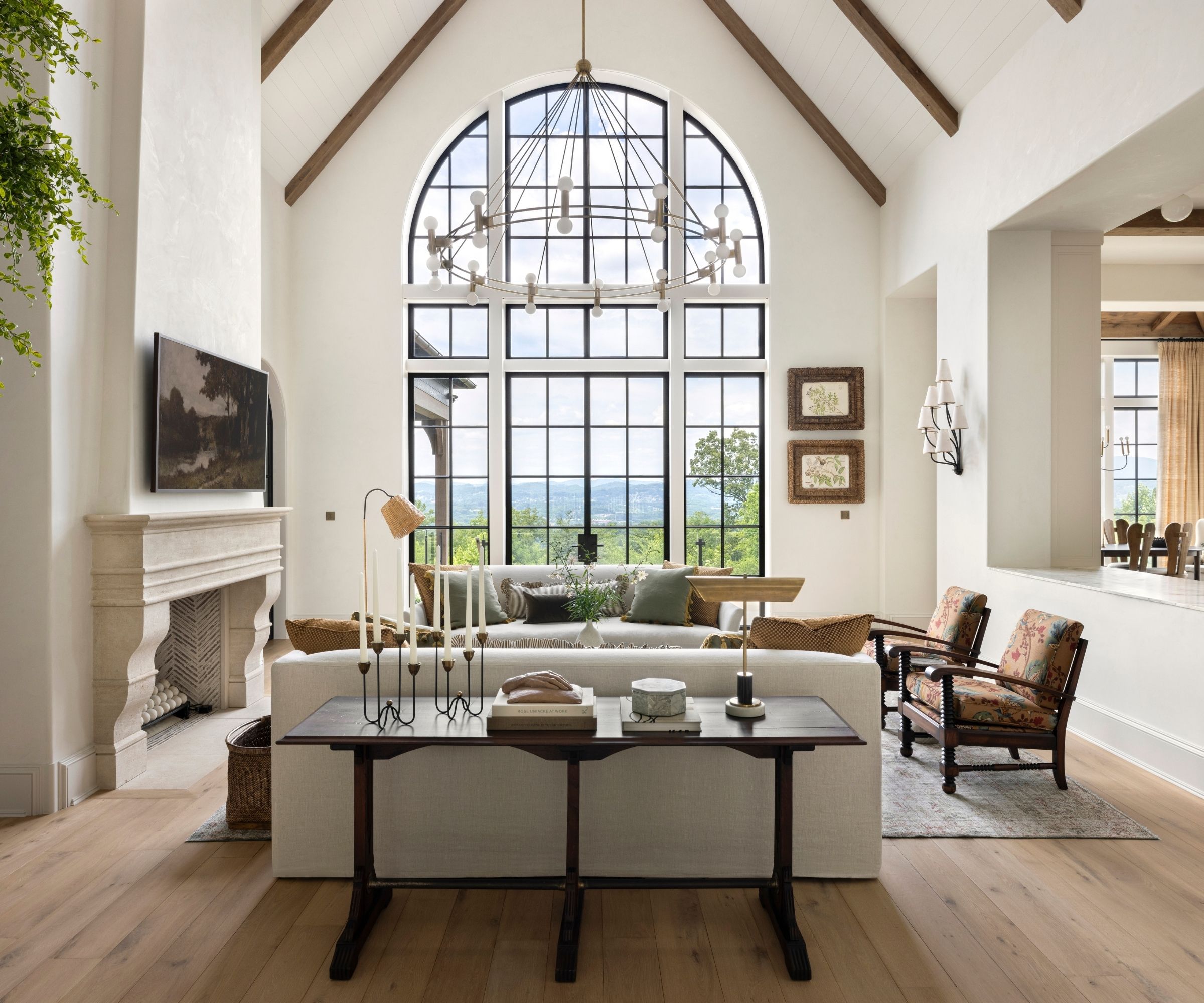 A white living room with vaulted ceilings and a large arched window