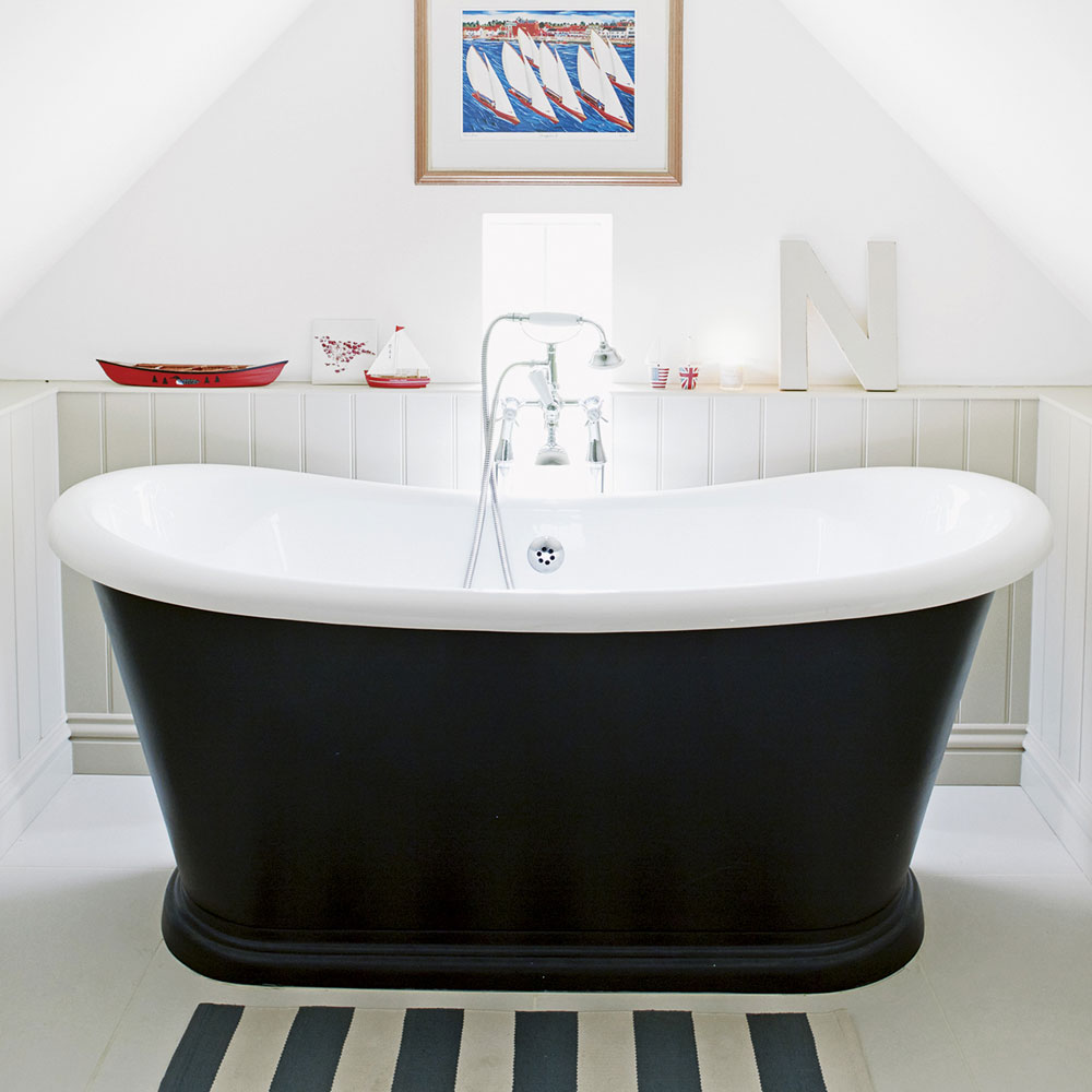 attic bathroom with white walls and black and white bathtub