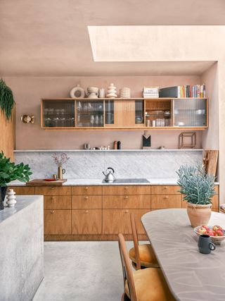 Plaster pink kitchen with wooden kitchen cabinets