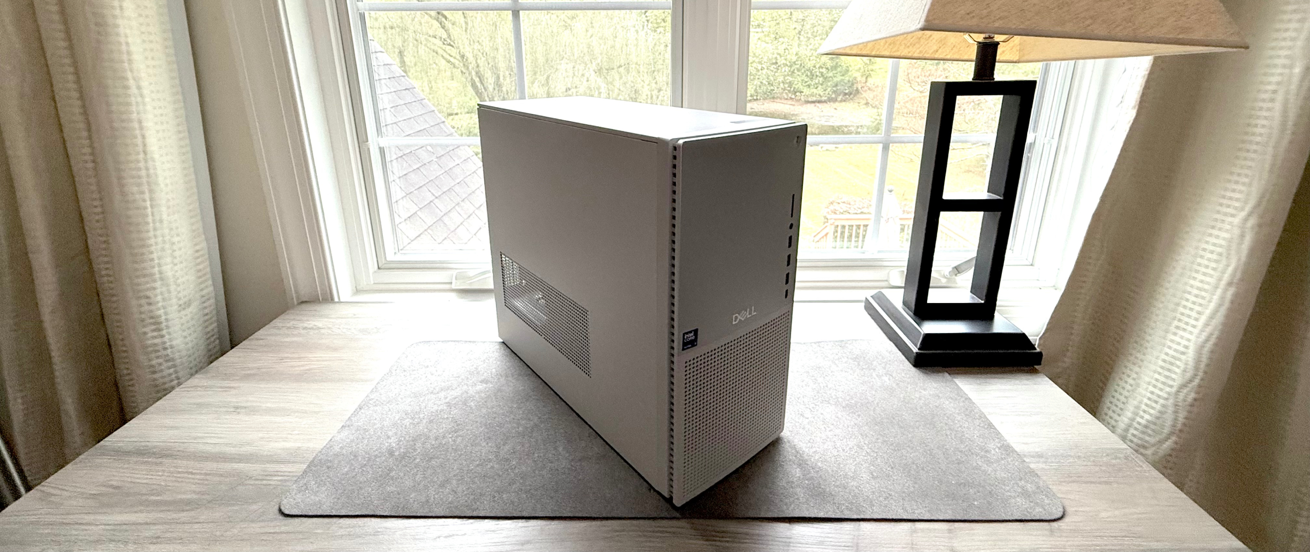 Dell Tower Plus resting on a desktop in front of a window