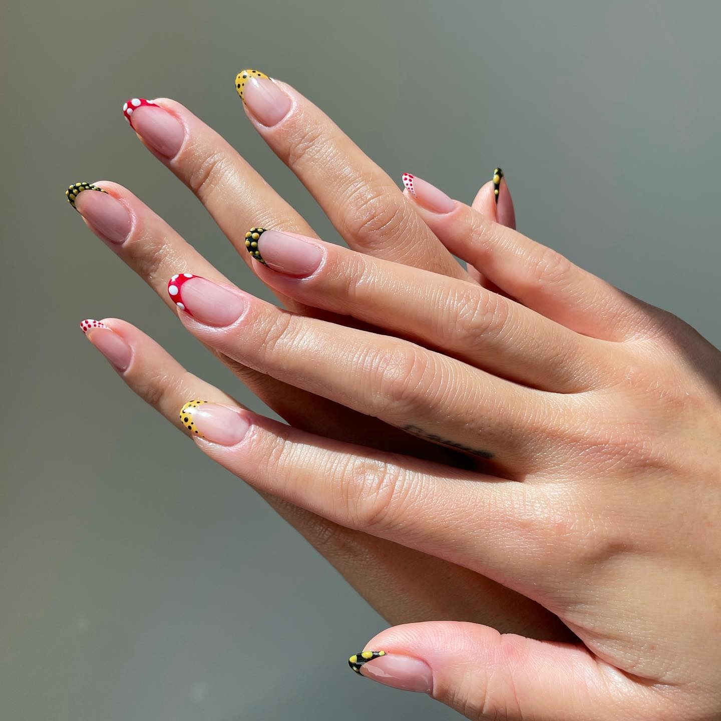 Red and white polka dot nails with back and yellow polka dots French tips