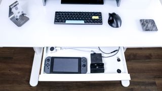 LiftSync Clear Plus' built-in drawer with a Nintendo Switch, a dock and other accessories inside