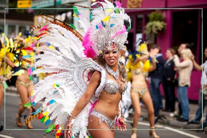 A woman wearing a headdress and wings at Notting Hill Carnival