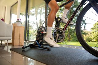 Image shows a cyclist riding a smart turbo trainer