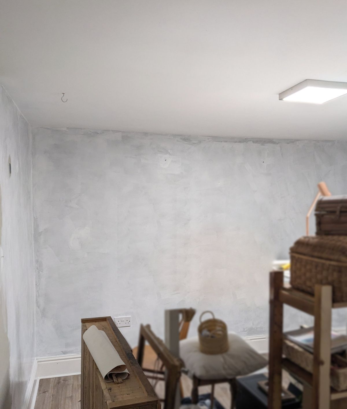 A wall with a first coat of white anti-mould paint