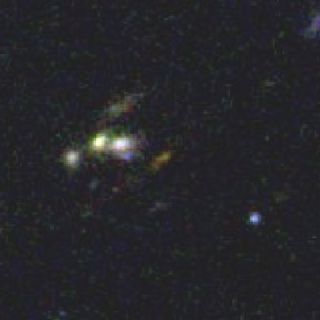 An ultra-distant galaxy (the pea-green blob near the center of the image) has "average" characteristics, compared to most other galaxies measured at this distance, which are unusually bright.